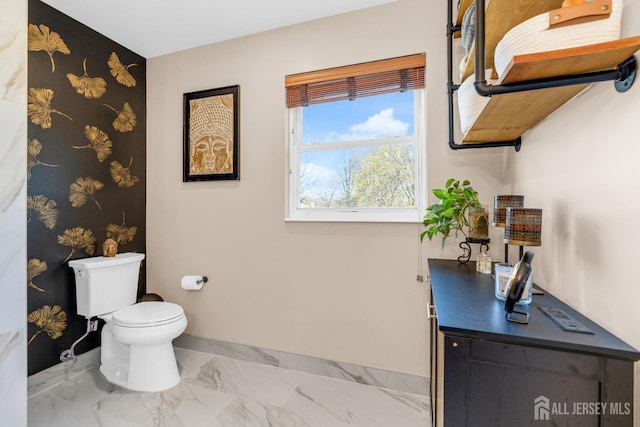 half bath featuring baseboards, toilet, and marble finish floor