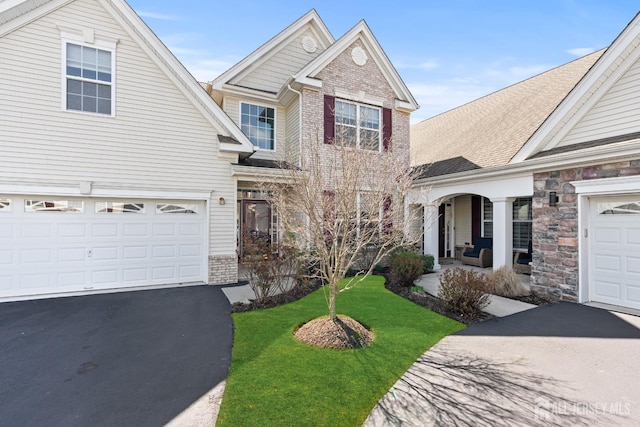 31 Mcgowan Ct, Old Bridge, NJ 08857 - traditional-style house featuring asphalt driveway, brick siding, a front yard, and a porch