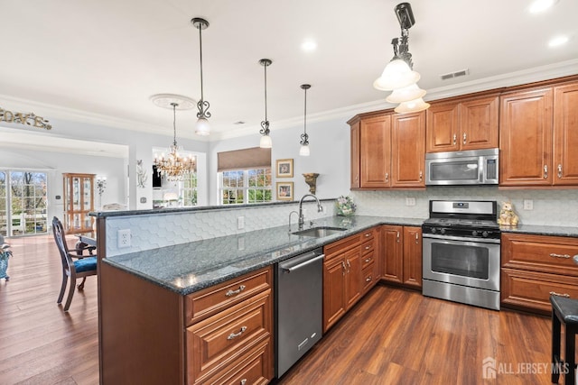 31 Mcgowan Ct, Old Bridge, NJ 08857 - kitchen featuring appliances with stainless steel finishes, a peninsula, brown cabinets, healthy amount of natural light, and ornamental molding