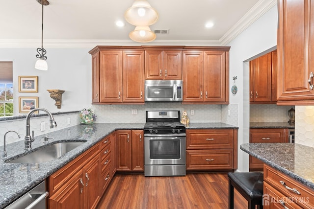31 Mcgowan Ct, Old Bridge, NJ 08857 - kitchen featuring appliances with stainless steel finishes, crown molding, dark wood finished floors, dark stone countertops, and brown cabinetry