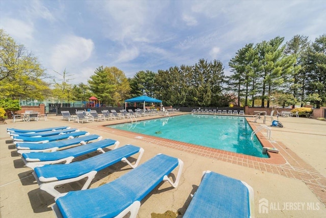 19 Pembrook Ave, North Brunswick, NJ 08902 - community pool featuring a patio area and view of wooded area