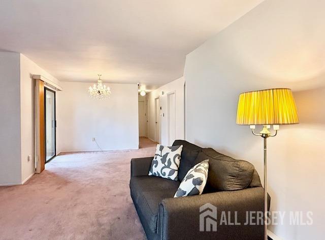 54 Amberly Dr Unit A, Manalapan, NJ 07726 - living area with a chandelier and carpet floors