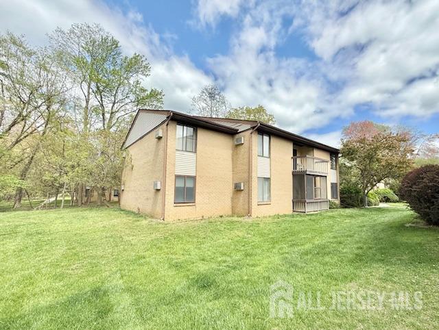 54 Amberly Dr Unit A, Manalapan, NJ 07726 - rear view of house featuring a yard, a balcony, and stucco siding