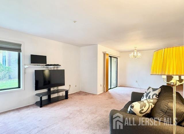 54 Amberly Dr Unit A, Manalapan, NJ 07726 - living area with a chandelier and light colored carpet
