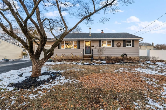 ranch-style house with fence, a chimney, and an attached garage