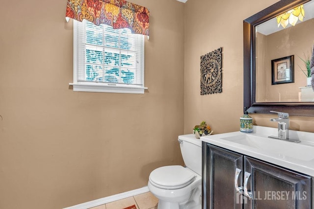 half bath with toilet, baseboards, tile patterned flooring, and vanity