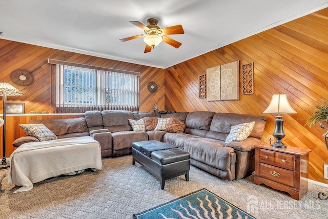 living room featuring crown molding, ceiling fan, and wooden walls