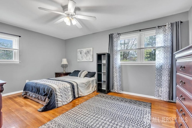 bedroom featuring baseboards, ceiling fan, and light wood finished floors