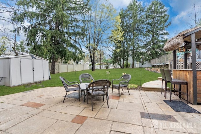 view of patio with a fenced backyard, a storage unit, an outdoor structure, and a trampoline