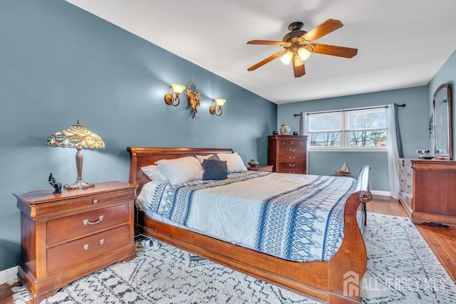 bedroom featuring a ceiling fan, baseboards, and wood finished floors