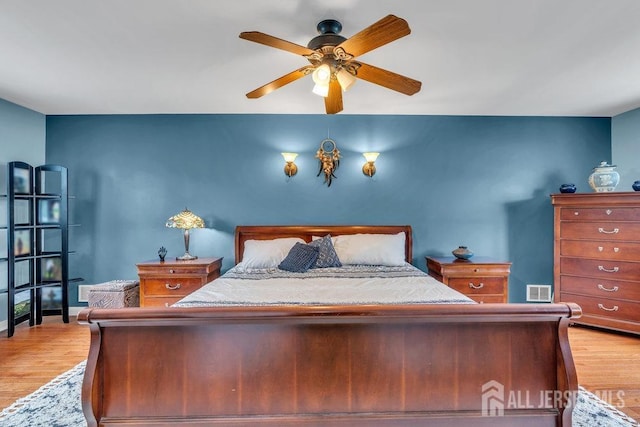 bedroom with light wood-style floors, baseboards, and a ceiling fan