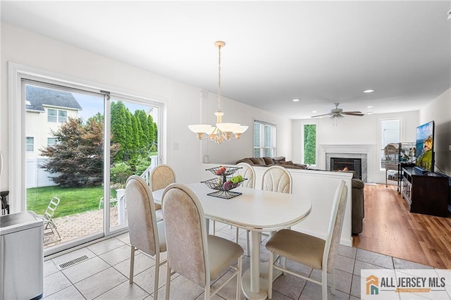 254 Wyoming Ave, Spotswood, NJ 08884 - dining space with a chandelier, a lit fireplace, recessed lighting, light tile patterned flooring, and ceiling fan