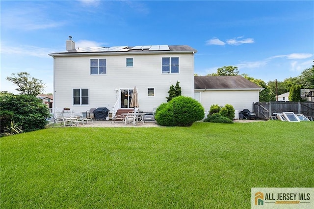 254 Wyoming Ave, Spotswood, NJ 08884 - back of house with roof mounted solar panels, a chimney, a patio, and entry steps