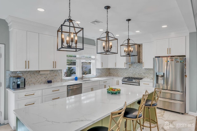 kitchen with appliances with stainless steel finishes, a chandelier, tasteful backsplash, a sink, and white cabinets