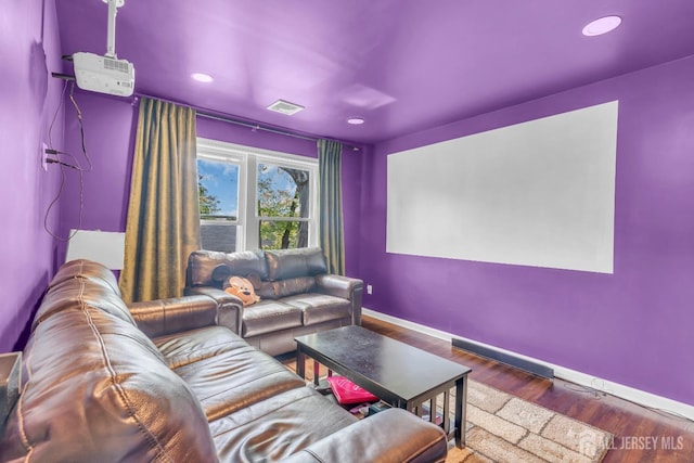 home theater room with baseboards, wood finished floors, and recessed lighting