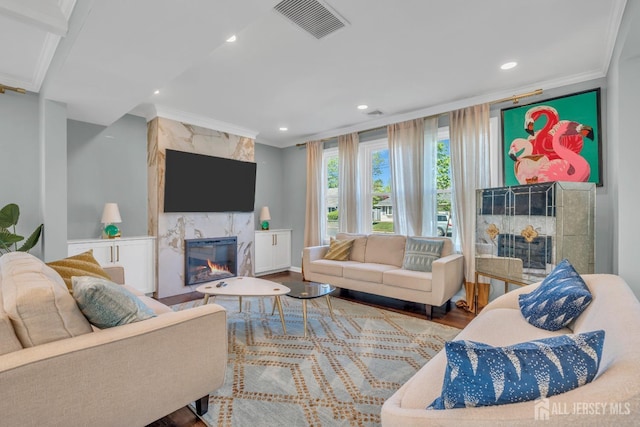 living area with a high end fireplace, ornamental molding, recessed lighting, and wood finished floors