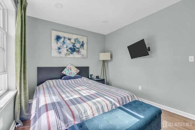 bedroom featuring wood finished floors and baseboards