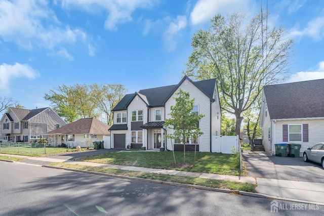view of front of home featuring asphalt driveway, a residential view, and an attached garage