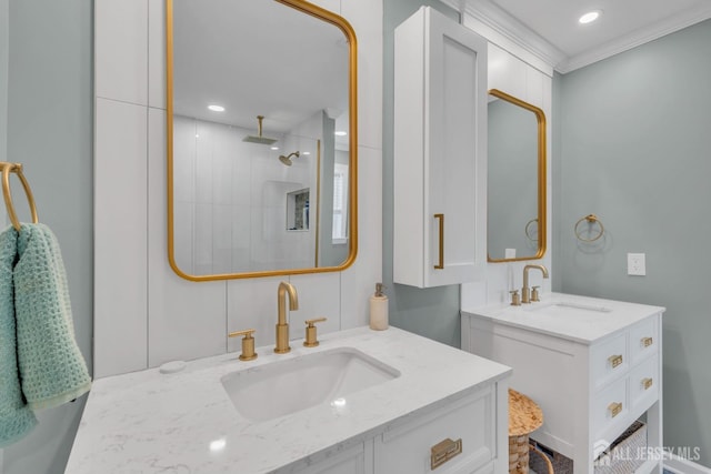 full bath with two vanities, a tile shower, recessed lighting, and ornamental molding