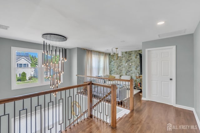 hall featuring an upstairs landing, a chandelier, wood finished floors, baseboards, and recessed lighting