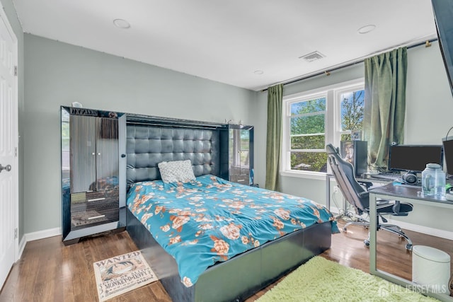 bedroom with wood finished floors, baseboards, and a desk