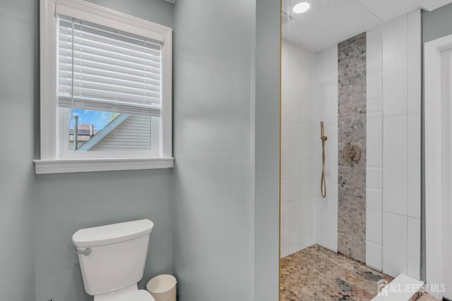full bathroom with tiled shower and toilet