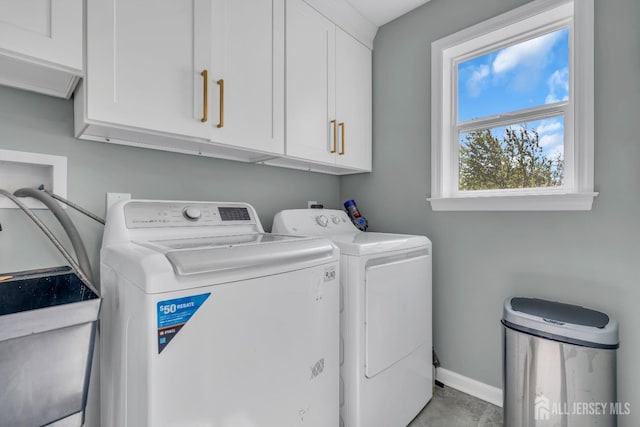laundry room with cabinet space, washer and clothes dryer, and baseboards