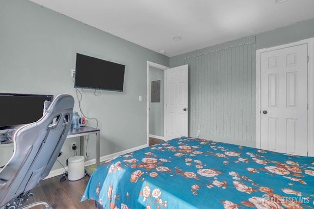 bedroom featuring wood finished floors, electric panel, and baseboards