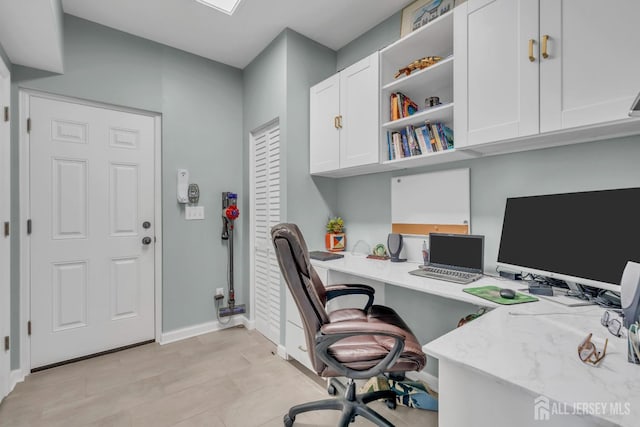 home office with built in desk and baseboards