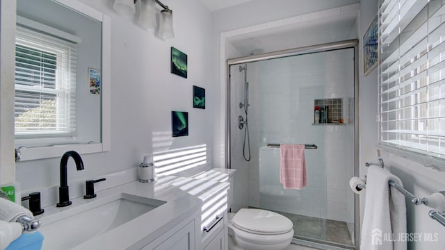 bathroom featuring toilet, vanity, and an enclosed shower