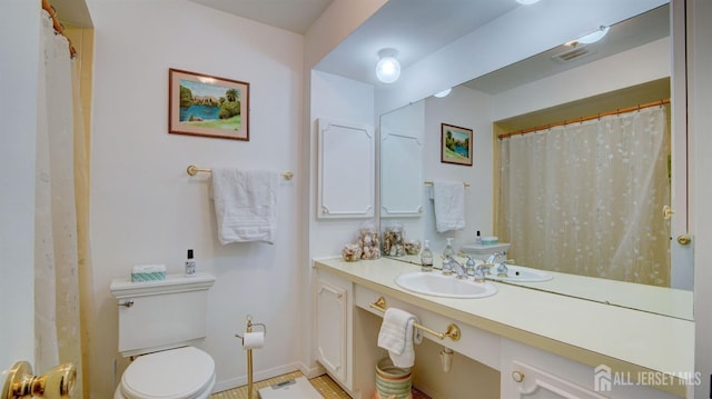 bathroom with toilet, vanity, and tile patterned flooring