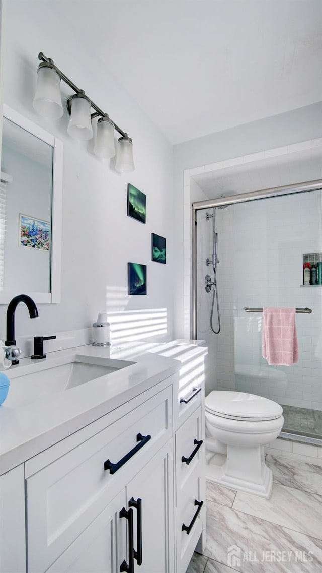 bathroom featuring walk in shower, vanity, and toilet