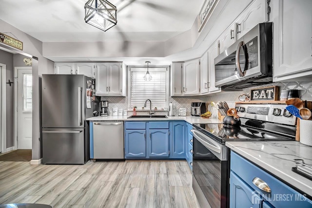 122 Concordia Cir Unit B, Monroe, NJ 08831 - kitchen with appliances with stainless steel finishes, blue cabinetry, a sink, and light wood-style flooring