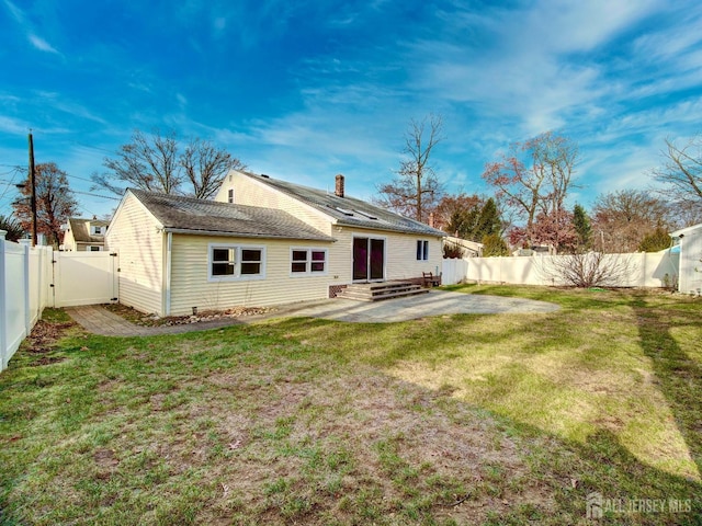 rear view of house featuring a patio and a lawn