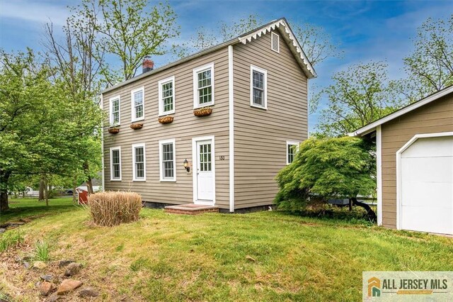 180 Blackwells Mills Rd, Franklin, NJ 08873 - back of house with a chimney, a lawn, and a garage