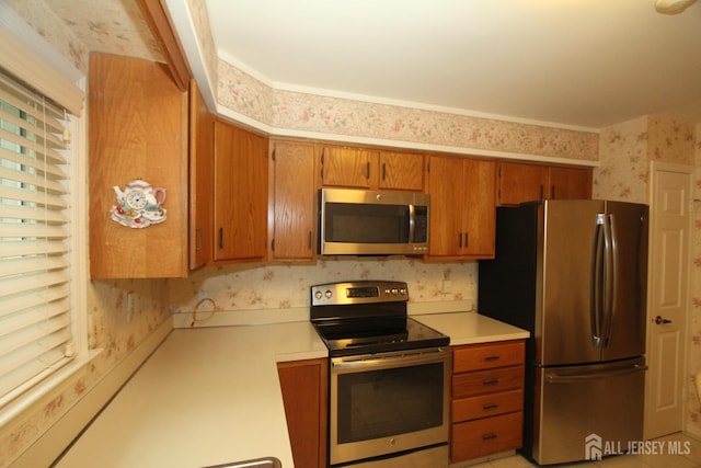 59-A Yorkshire Dr, Monroe, NJ 08831 - kitchen with appliances with stainless steel finishes, wallpapered walls, brown cabinetry, and light countertops