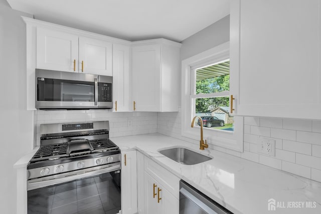 97 Battle Hill Ave, Springfield, NJ 07081 - kitchen with appliances with stainless steel finishes, white cabinetry, light stone countertops, and tasteful backsplash