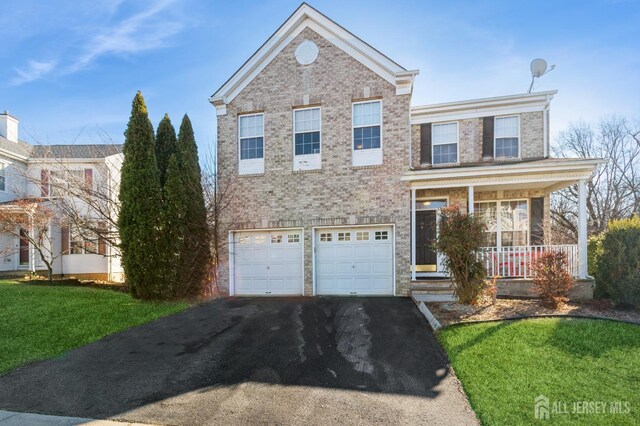 view of front facade with a garage, a front yard, and covered porch