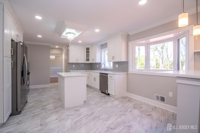 4 Harvey Rd, South Brunswick, NJ 08852 - kitchen featuring appliances with stainless steel finishes, a kitchen island, decorative backsplash, white cabinetry, and light countertops