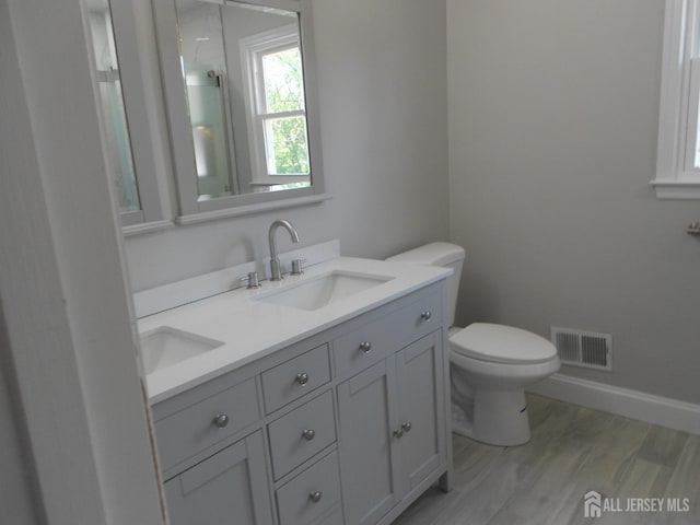 4 Harvey Rd, South Brunswick, NJ 08852 - full bathroom with toilet, double vanity, baseboards, a shower, and wood finished floors