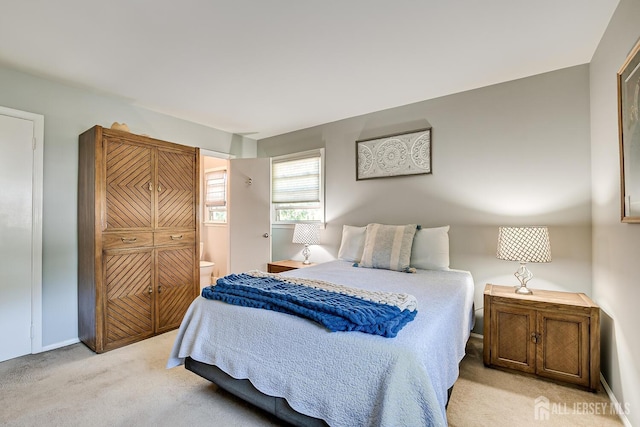 carpeted bedroom featuring ensuite bathroom