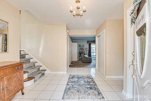 tiled foyer entrance featuring a notable chandelier