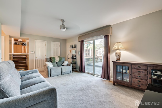 carpeted living room with ceiling fan