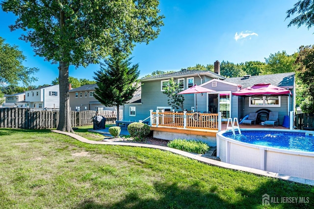 back of property featuring a swimming pool side deck and a yard