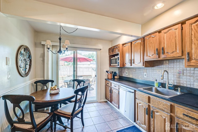 kitchen with sink, hanging light fixtures, stainless steel appliances, backsplash, and light tile patterned flooring