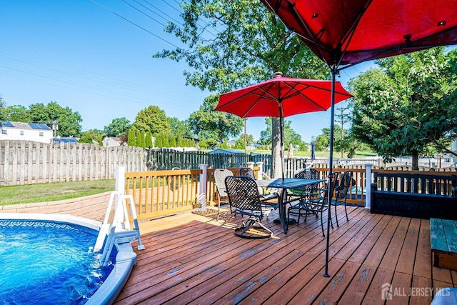 wooden deck featuring a fenced in pool