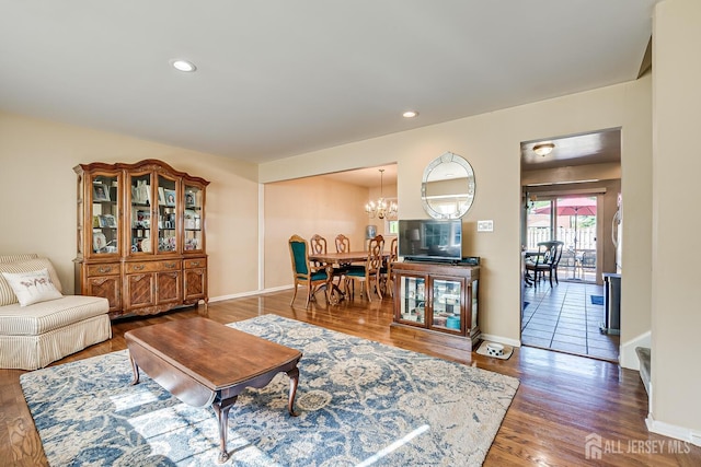 living room featuring wood-type flooring and a notable chandelier