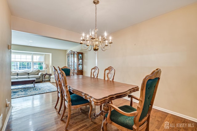 dining space featuring hardwood / wood-style floors and a notable chandelier