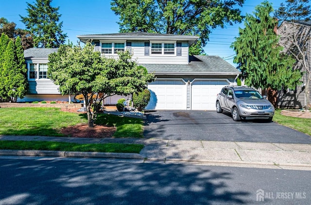 view of front of house featuring a garage and a front lawn