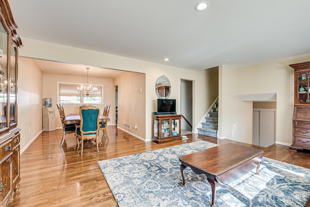 living room with a chandelier and light hardwood / wood-style floors